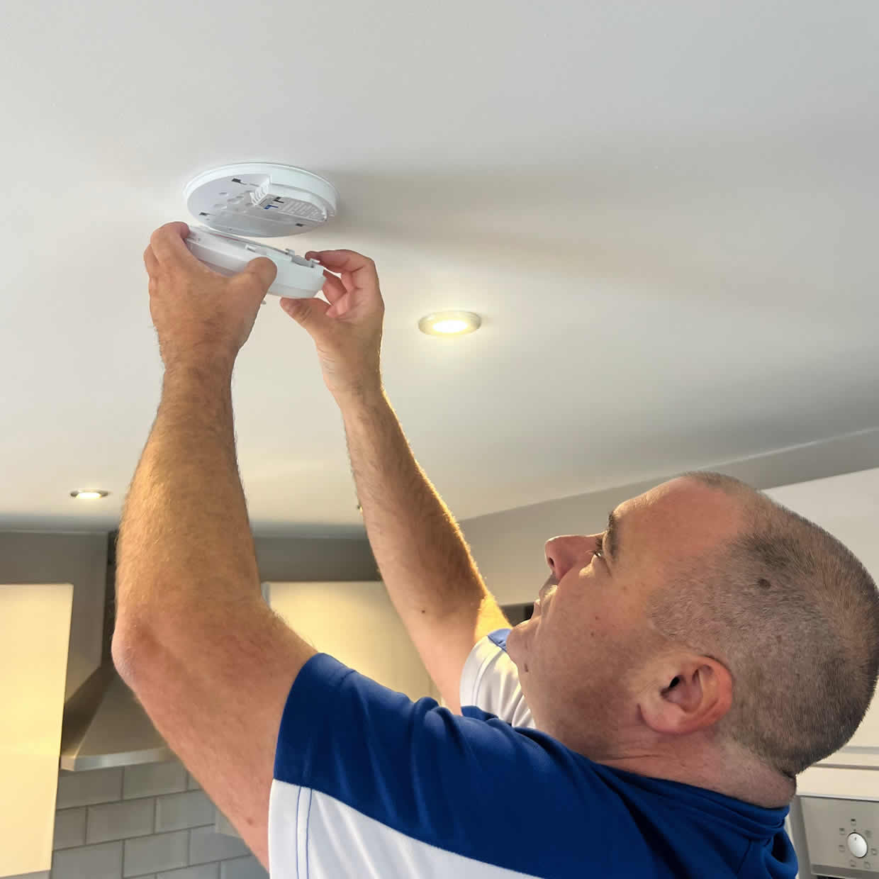 Smoke alarm being installed on a ceiling in Kirkcaldy